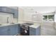 This kitchen has blue cabinets, stainless steel appliances, and an open view to the living room at 5048 5Th S Ave, St Petersburg, FL 33707