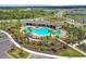 Aerial view of a community pool, cabanas, and lounge chairs surrounded by palm trees and lush landscaping at 5214 Granite Dust Pl, Palmetto, FL 34221
