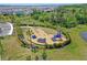Aerial view of a community playground with slides, a climbing wall, and a safe, fenced play area at 5214 Granite Dust Pl, Palmetto, FL 34221