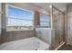 This bright bathroom has a tub and a glass-enclosed shower with natural light at 5214 Granite Dust Pl, Palmetto, FL 34221