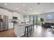 Modern kitchen with stainless steel appliances, granite countertops, island with seating and an adjacent living area at 5214 Granite Dust Pl, Palmetto, FL 34221