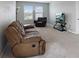 Comfortable living room with neutral carpet, natural light, and a reclining sofa at 5214 Granite Dust Pl, Palmetto, FL 34221
