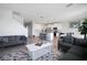 Open-concept living room with modern furnishings and a view into the kitchen with stainless steel appliances at 5214 Granite Dust Pl, Palmetto, FL 34221