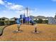 Community playground with a slide, climbing structure, and spring riders surrounded by wood chips at 5214 Granite Dust Pl, Palmetto, FL 34221