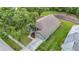 Aerial view of a home with a green lawn, mature trees, and a paved driveway at 5809 Silas Creek Ln, Wesley Chapel, FL 33545