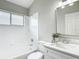 Bathroom features a tiled tub-shower, decorative mirror, and vanity with white cabinets at 5809 Silas Creek Ln, Wesley Chapel, FL 33545