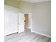 Bright bedroom features sleek, light-toned floors and a closet with white bi-fold doors at 5809 Silas Creek Ln, Wesley Chapel, FL 33545