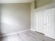 This bedroom features light wood floors, a closet with white doors, and fresh light-grey paint at 5809 Silas Creek Ln, Wesley Chapel, FL 33545