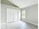 Light-filled bedroom featuring wood floors, a closet with white doors, and a window with natural light at 5809 Silas Creek Ln, Wesley Chapel, FL 33545