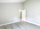 Spacious bedroom with light wood floors, painted in light-grey, and closet with white doors at 5809 Silas Creek Ln, Wesley Chapel, FL 33545