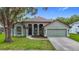 Charming single-story home featuring a well-manicured lawn, attached garage, and inviting curb appeal at 5809 Silas Creek Ln, Wesley Chapel, FL 33545