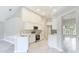Open-concept kitchen featuring white cabinets, stainless appliances, and light wood floors, complemented by an open layout at 5809 Silas Creek Ln, Wesley Chapel, FL 33545