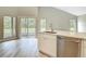 Well-lit kitchen island with sink, stainless steel dishwasher, stone countertops, and views of the green backyard at 5809 Silas Creek Ln, Wesley Chapel, FL 33545