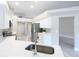 Bright kitchen with modern stainless steel appliances, white cabinets, stone countertops, and plenty of natural light at 5809 Silas Creek Ln, Wesley Chapel, FL 33545