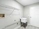 Simple laundry room with utility sink, wire shelving, and painted in a light neutral color at 5809 Silas Creek Ln, Wesley Chapel, FL 33545