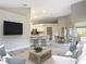 Bright living room featuring an open floor plan with modern, neutral-toned decor and wood-look flooring at 5809 Silas Creek Ln, Wesley Chapel, FL 33545