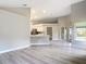 Open-concept living space with kitchen access, light-colored floors, and backyard views from large glass windows at 5809 Silas Creek Ln, Wesley Chapel, FL 33545