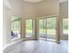 Brightly lit living space with access to the patio via glass windows and sliders, with views of the landscaped yard at 5809 Silas Creek Ln, Wesley Chapel, FL 33545