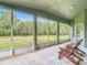 Screened-in porch offering beautiful views of the backyard, and chairs to enjoy the outdoors at 5809 Silas Creek Ln, Wesley Chapel, FL 33545