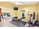 Bright exercise room featuring tile flooring, a variety of exercise equipment, and an adjacent sitting room with pool views at 6011 Pratt St, Tampa, FL 33647