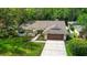 Charming single-Gathering home with a well-manicured lawn, mature trees, and a two-car garage at 6011 Pratt St, Tampa, FL 33647