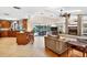 Open-concept living room with a fireplace, island seating, and a seamless transition to the outdoor pool area at 6011 Pratt St, Tampa, FL 33647