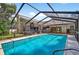 The screened-in pool is surrounded by lush greenery, creating a peaceful retreat at 6011 Pratt St, Tampa, FL 33647