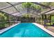 Private screened-in pool surrounded by tropical landscaping offers a relaxing outdoor retreat at 6011 Pratt St, Tampa, FL 33647