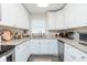 Well-lit kitchen with white cabinets, granite countertops, and stainless steel appliances at 6412 S Richard Ave, Tampa, FL 33616