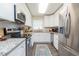 Modern kitchen featuring stainless steel appliances, white cabinets, and granite countertops at 6412 S Richard Ave, Tampa, FL 33616