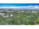 An aerial view of the neighborhood shows mature trees and a glimpse of the water at 6901 Arbor Oaks Ct, Bradenton, FL 34209