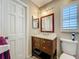 This bathroom features a wood vanity with a marble countertop and decorative mirror at 6901 Arbor Oaks Ct, Bradenton, FL 34209