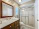 Clean bathroom with a marble vanity, enclosed glass shower, and a window for natural light at 6901 Arbor Oaks Ct, Bradenton, FL 34209