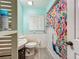 Bathroom features include light blue walls, wood-look floors, and a colorful shower curtain at 6901 Arbor Oaks Ct, Bradenton, FL 34209