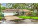 Charming single-story home with a well-manicured lawn and mature trees, creating a welcoming curb appeal at 6901 Arbor Oaks Ct, Bradenton, FL 34209