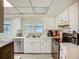Well-lit kitchen featuring white cabinetry, modern appliances, and tile flooring at 6901 Arbor Oaks Ct, Bradenton, FL 34209