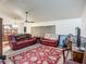 Inviting living room features dual leather couches, a ceiling fan, and a decorative floral area rug at 6901 Arbor Oaks Ct, Bradenton, FL 34209