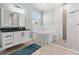 Bright bathroom featuring a soaking tub, marble accent walls, and walk-in shower at 716 Laurel Ave, Venice, FL 34285