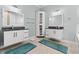 Bright bathroom featuring dual vanities with dark countertops and matching bath mats at 716 Laurel Ave, Venice, FL 34285