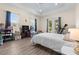 Bright bedroom with tray ceiling, hard wood floors, and double doors leading to the backyard at 716 Laurel Ave, Venice, FL 34285