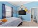 Bedroom with blue walls, wood-look floors, and large window, creating a bright and comfortable space at 716 Laurel Ave, Venice, FL 34285