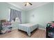 Bedroom with wood-look floors, ceiling fan, large window, and light green walls, creating a comfortable space at 716 Laurel Ave, Venice, FL 34285