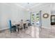 Bright dining room featuring an ornate light fixture, tile floors, and French doors to the patio at 716 Laurel Ave, Venice, FL 34285