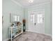 Home foyer featuring tiled floors, white double doors, and a charming accent table with decor at 716 Laurel Ave, Venice, FL 34285