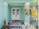 Inviting front porch with double doors, tiled flooring, and tropical plants in decorative white rock at 716 Laurel Ave, Venice, FL 34285