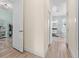Bright hallway featuring wood floors, leading to a bathroom with a soaking tub and dual vanities at 716 Laurel Ave, Venice, FL 34285