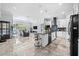 Open-concept kitchen and living space with an island, white cabinets, and stainless steel appliances at 716 Laurel Ave, Venice, FL 34285
