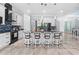 Modern kitchen features white cabinetry, stainless steel appliances, a large island with seating and stylish backsplash at 716 Laurel Ave, Venice, FL 34285