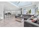 The open concept living room boasts tile flooring, large windows, recessed lighting, and a view of the kitchen and dining area at 716 Laurel Ave, Venice, FL 34285