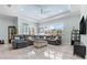Comfortable living room featuring a tray ceiling, tiled floors, large windows and a large sectional couch at 716 Laurel Ave, Venice, FL 34285